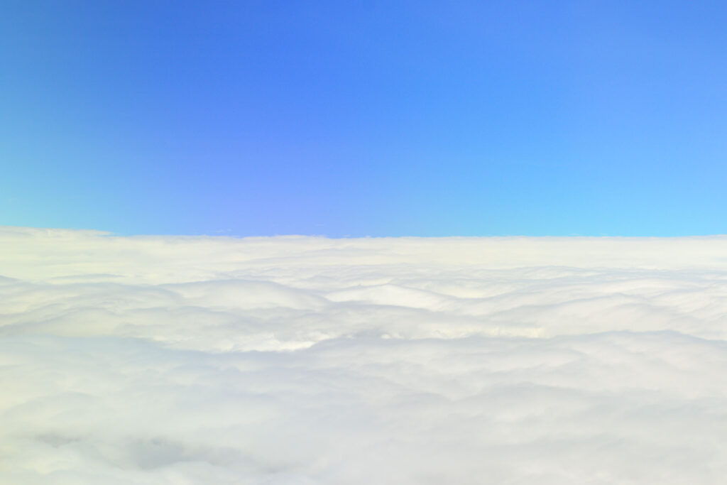 Image of a sea of clouds from outside of an airplane window
