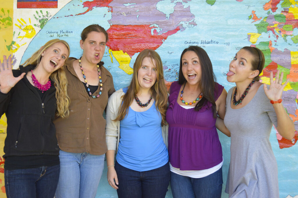 Five women wearing paper necklaces made by Mujeres: Cambia in Ecuador